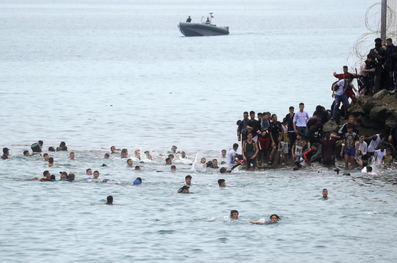 Dozens of migrants attempting to cross the Morocco-Spain border at Ceuta on May 18, 2021 (by Jon Nazca/Reuters)